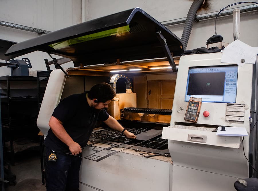 Technician preparing sheet metal on the laser-cutting machine